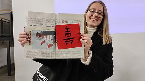 Teilnehmerin zeigt chinesisches Schriftzeichen